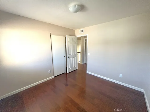 an empty room with wooden floor and sliding door