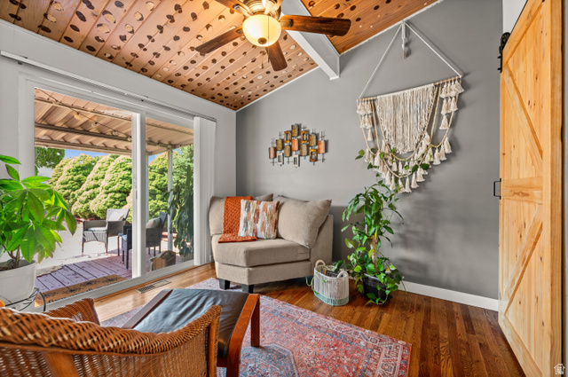 909 Rancho Boulevard Ogden, UT 84404 - Photo 5 of 27 Vaulted wood-paneled ceiling with exposed beams and ceiling fan, hardwood flooring, sliding glass patio doors, and a natural wood barn door
