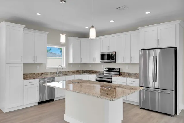 an empty room with wooden floor mirror and windows