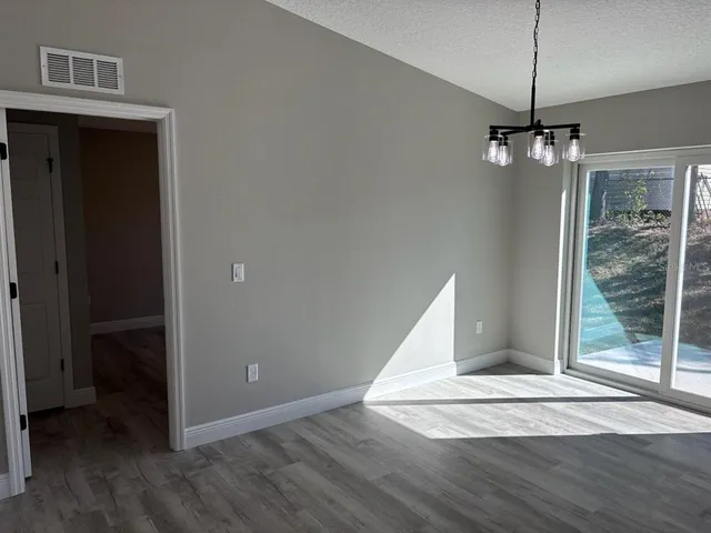 a view of a livingroom with wooden floor kitchen and window