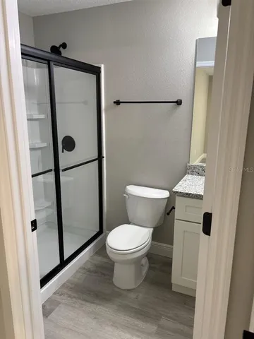 a bathroom with a granite countertop sink a toilet and mirror