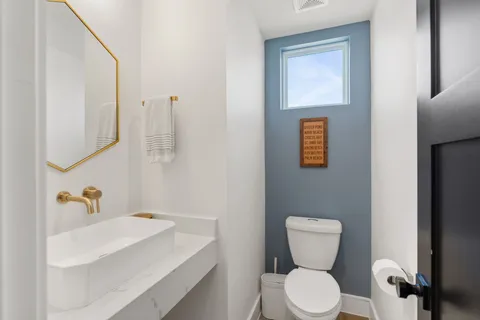 a bathroom with a toilet sink and mirror