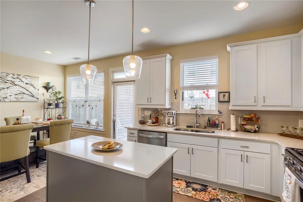 76 Garrison Drive Winder, GA 30680 - Photo 12 of 26 a kitchen with a stove a sink a center island and windows