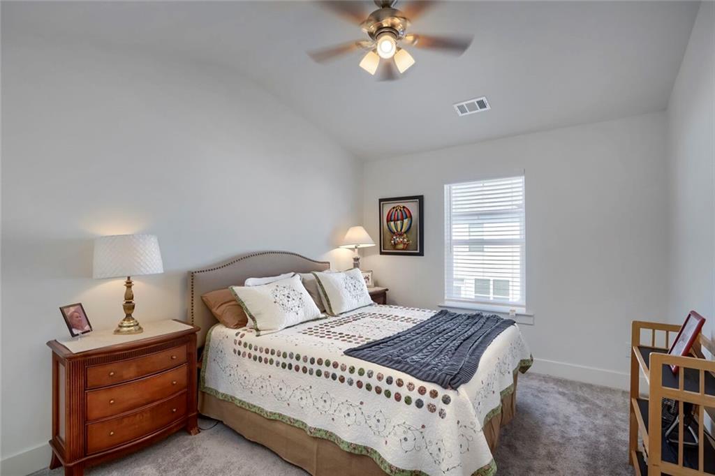 76 Garrison Drive Winder, GA 30680 - Photo 16 of 26 a bedroom with a bed window and a chandelier