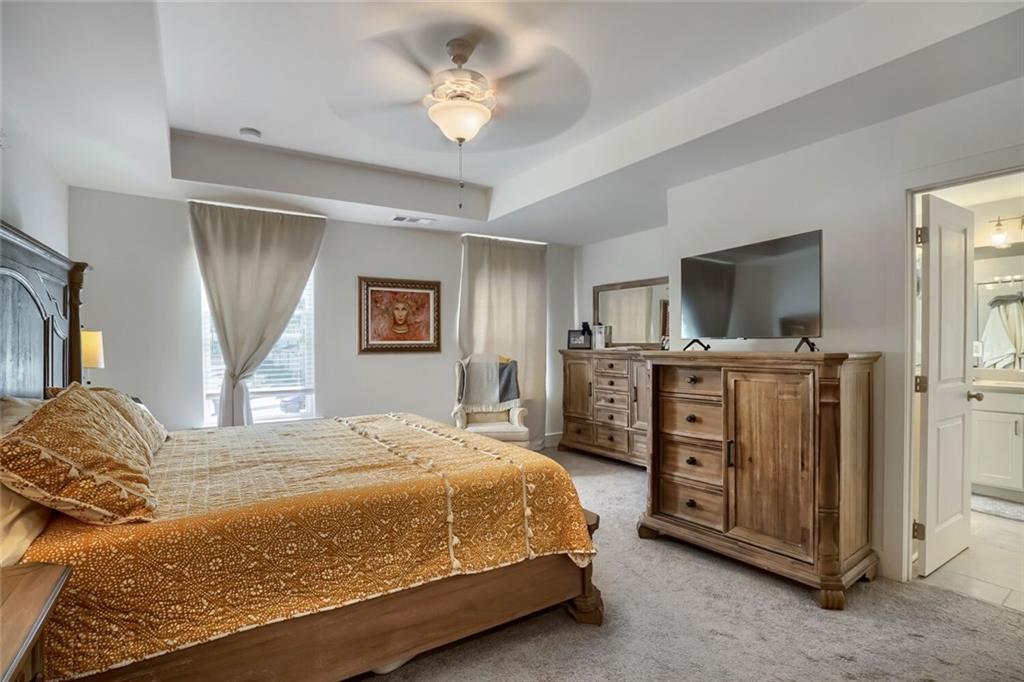 76 Garrison Drive Winder, GA 30680 - Photo 17 of 26 a bedroom with a bed and a flat tv screen on dresser