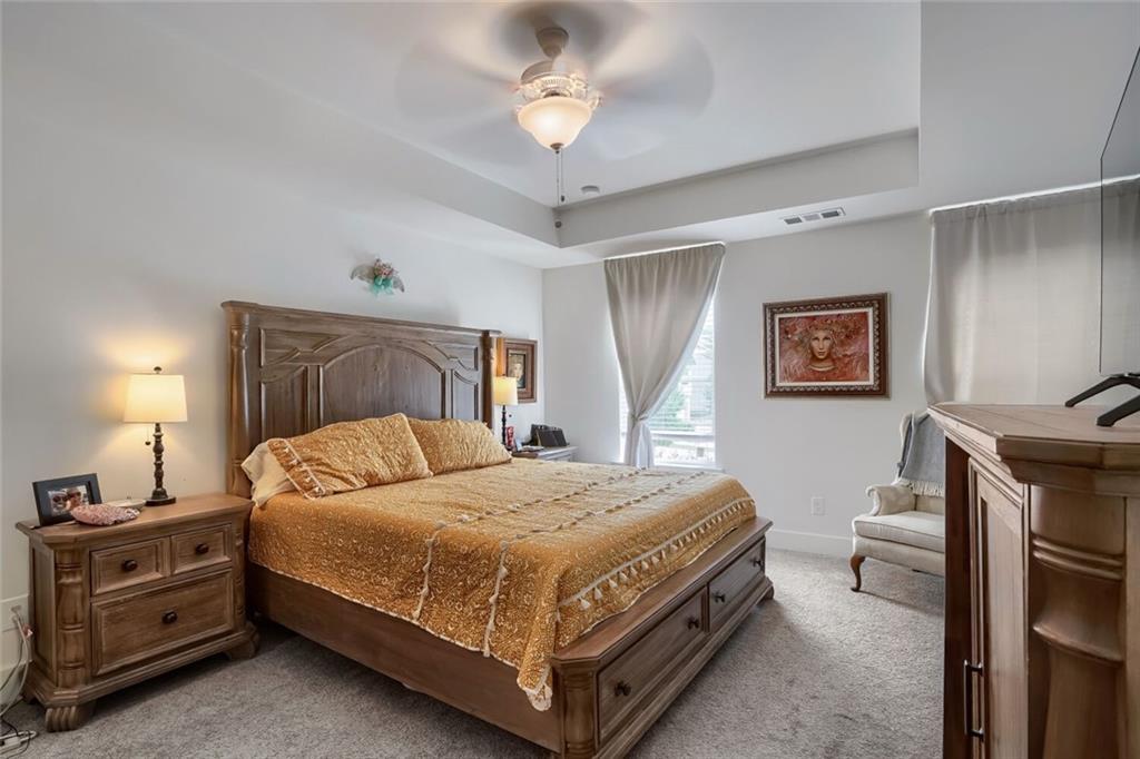76 Garrison Drive Winder, GA 30680 - Photo 18 of 26 a bedroom with a bed and a chandelier