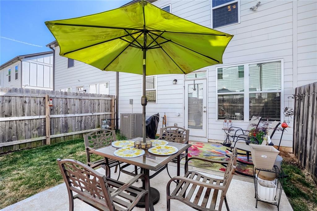 76 Garrison Drive Winder, GA 30680 - Photo 22 of 26 a patio with a table and chairs under an umbrella