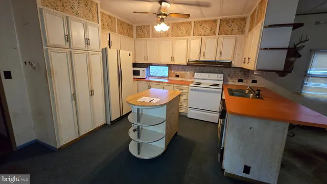 a kitchen with stainless steel appliances granite countertop a refrigerator a stove and a sink with wooden floor