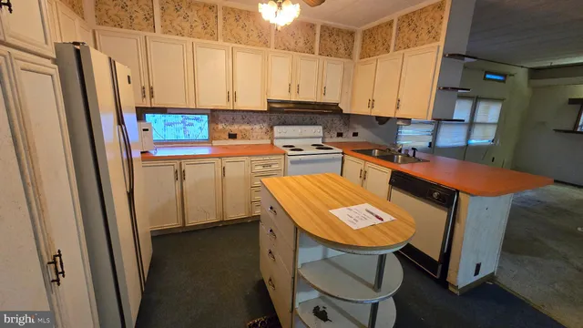 a kitchen with stainless steel appliances a stove a refrigerator and a sink
