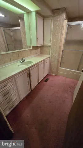 a view of bathroom with sink mirror and window