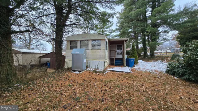 a front view of house with yard and trees in the background