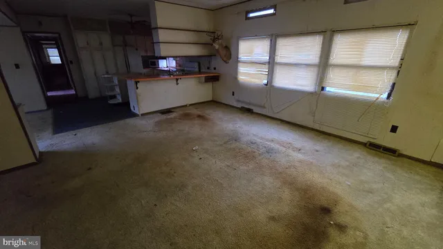 an empty room with a fireplace and windows