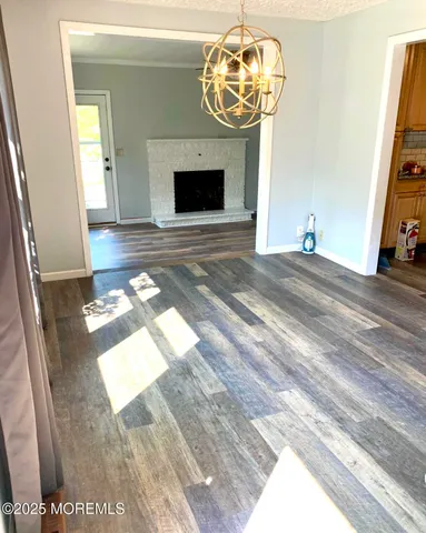a view of a livingroom with wooden floor and a chandelier