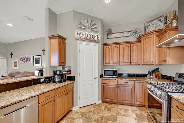 a kitchen with stainless steel appliances granite countertop a sink stove and cabinets