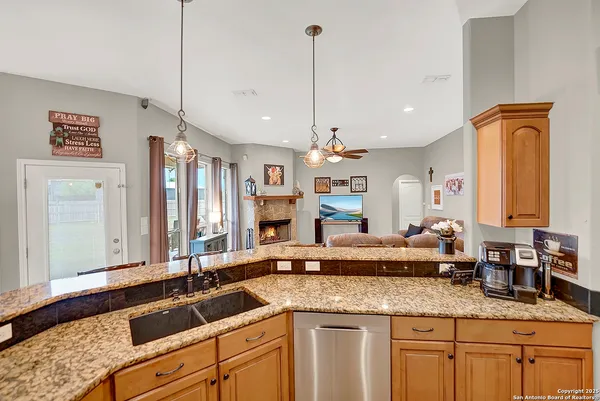 a kitchen with stainless steel appliances granite countertop a stove a sink dishwasher and cabinets with wooden floor