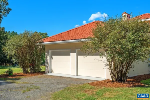 a view of a patio with table and chairs plants and large trees