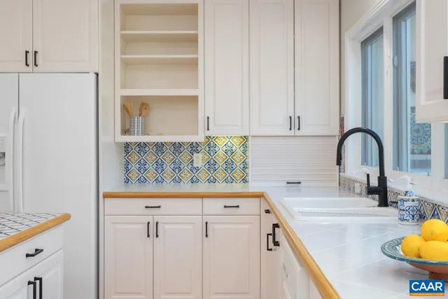 a bathroom with a granite countertop tub sink and mirror