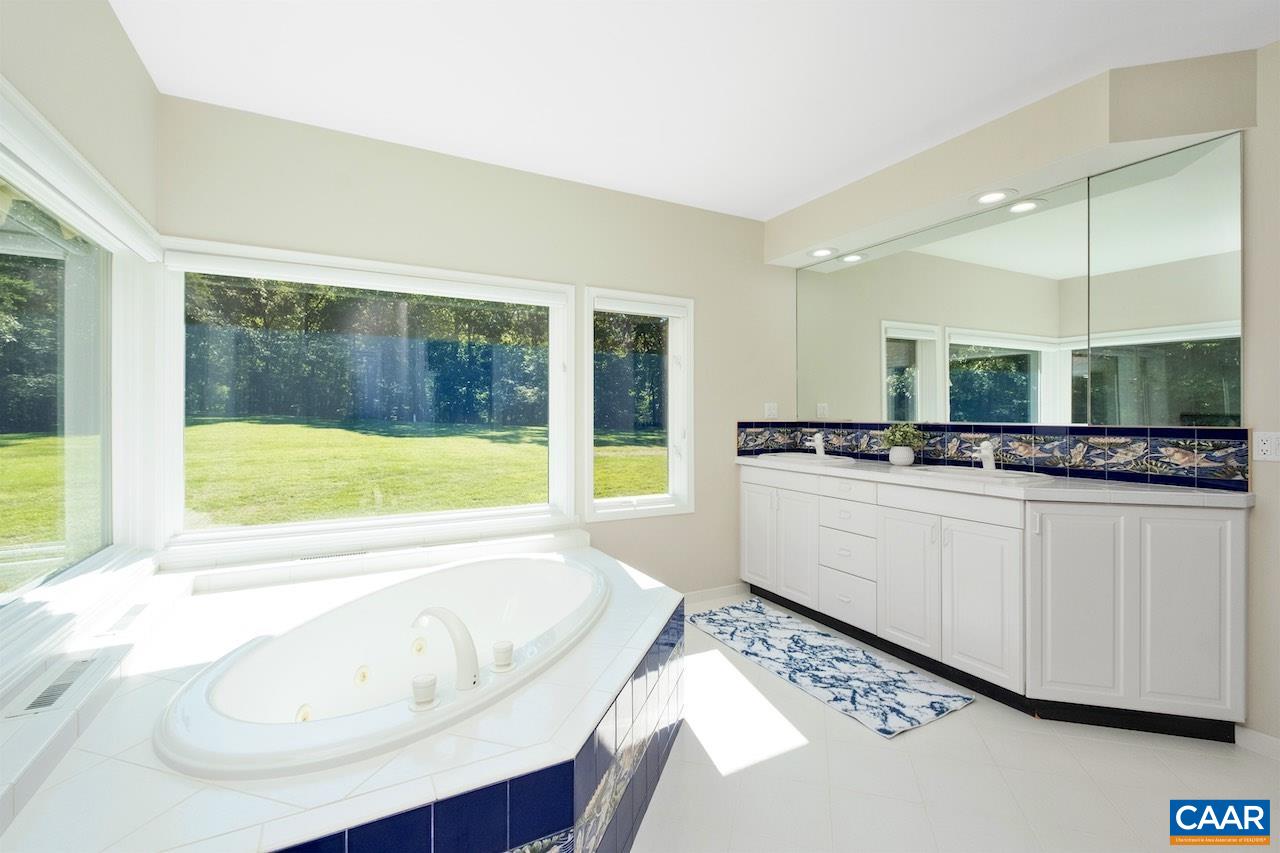 8540 Taylor Creek Road Afton, VA 22920 - Photo 45 of 71 a bathroom with a granite countertop tub sink and mirror