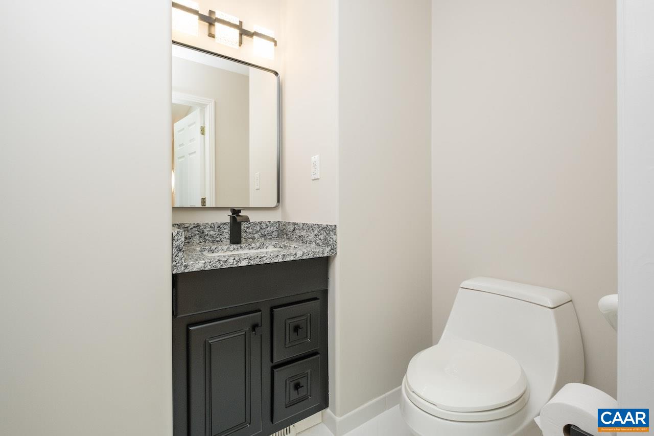 8540 Taylor Creek Road Afton, VA 22920 - Photo 49 of 71 a bathroom with a granite countertop toilet sink and mirror