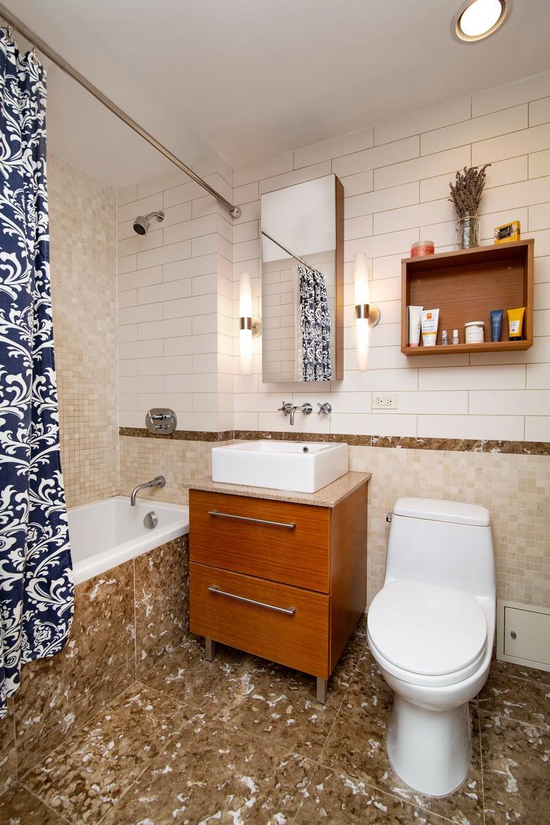 a bathroom with a granite countertop toilet sink and mirror
