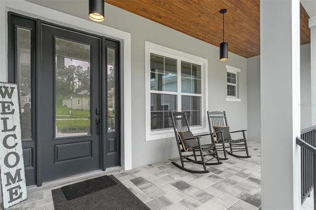 a living room with furniture kitchen view and a large window