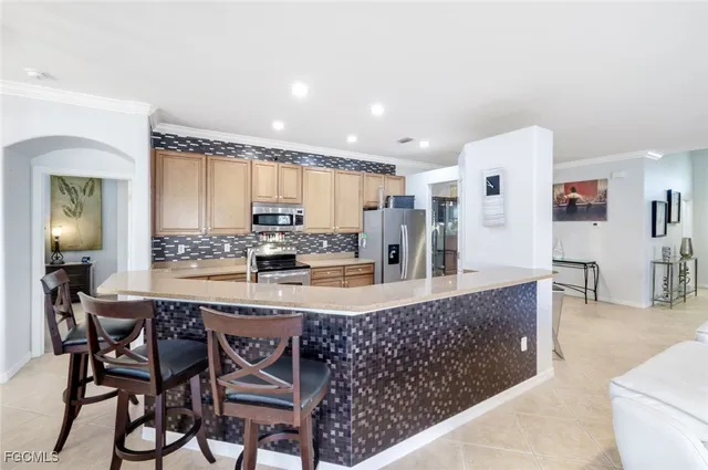 a large kitchen with granite countertop a counter top space and stainless steel appliances