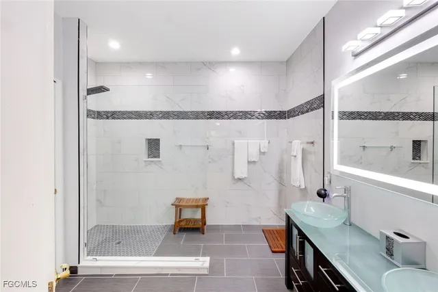 a bathroom with a granite countertop sink a toilet and shower
