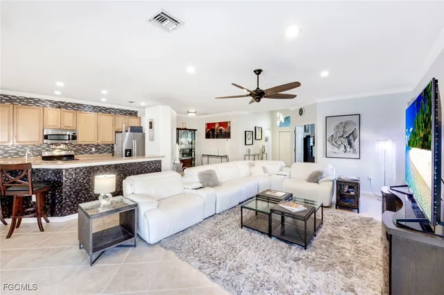a living room with furniture kitchen view and a flat screen tv