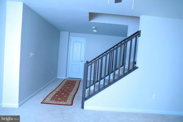 a view of staircase with railing and white walls