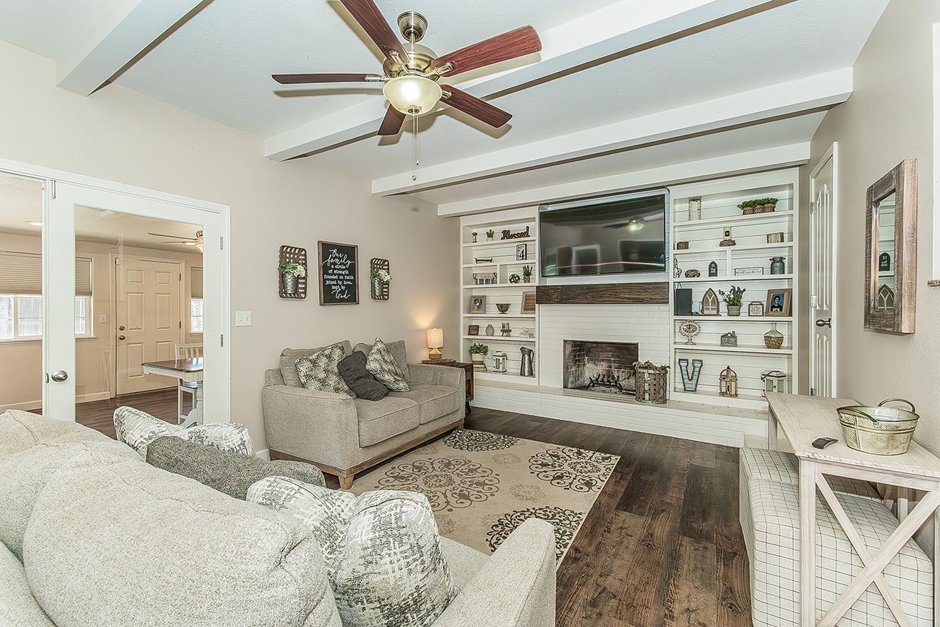 1563 South Klein Avenue Reedley, CA 93654 - Photo 11 of 81 a living room with furniture a fireplace and a flat screen tv