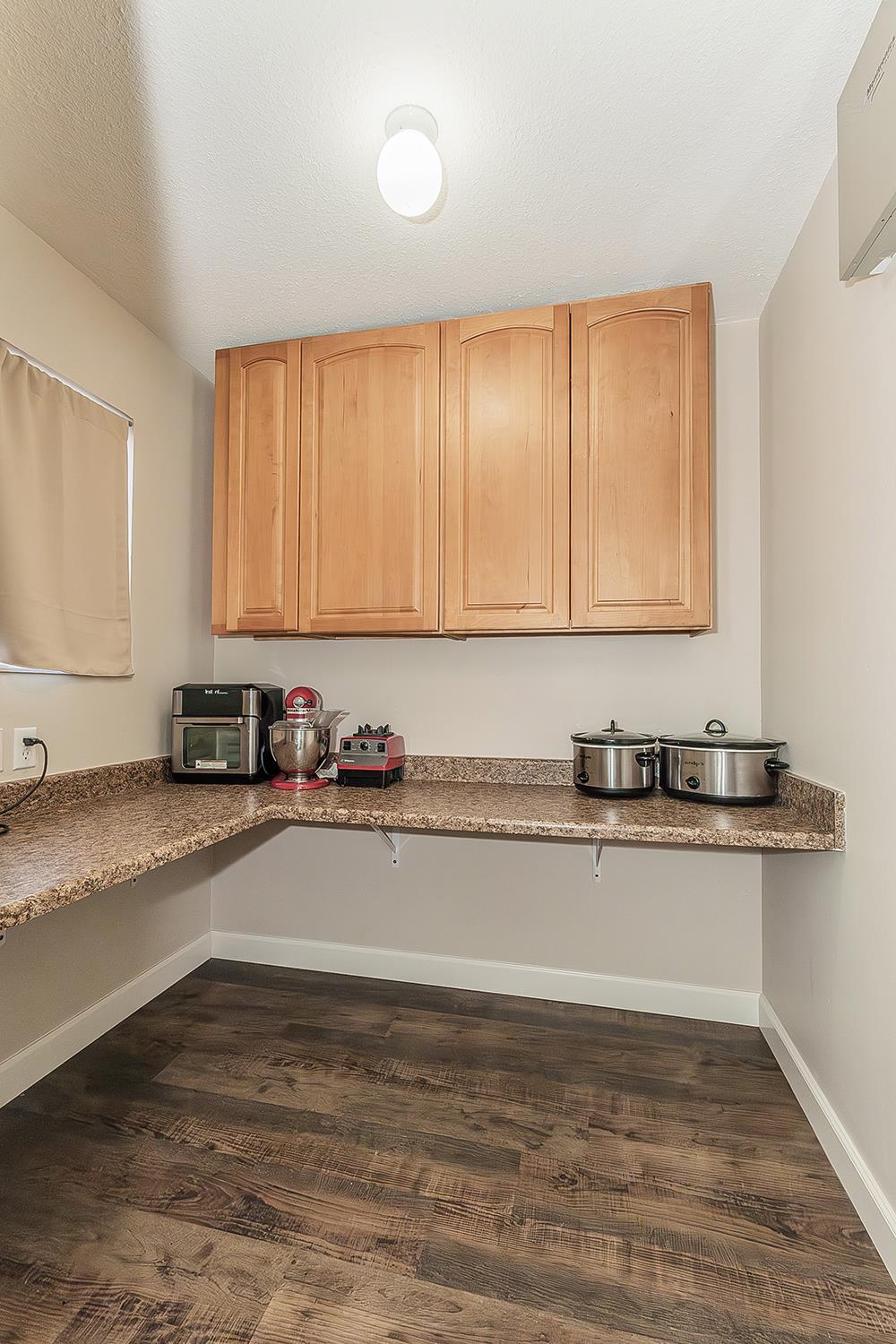 1563 South Klein Avenue Reedley, CA 93654 - Photo 13 of 81 a view of a kitchen with kitchen island a sink wooden floor and a counter top space