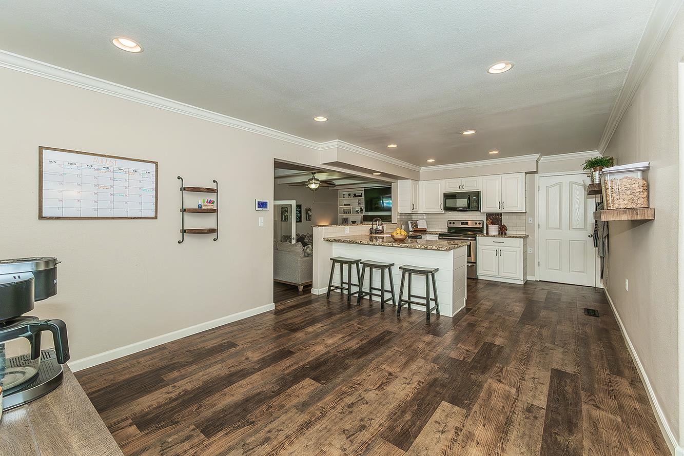 1563 South Klein Avenue Reedley, CA 93654 - Photo 20 of 81 a kitchen with stainless steel appliances kitchen island granite countertop a refrigerator and a stove top oven