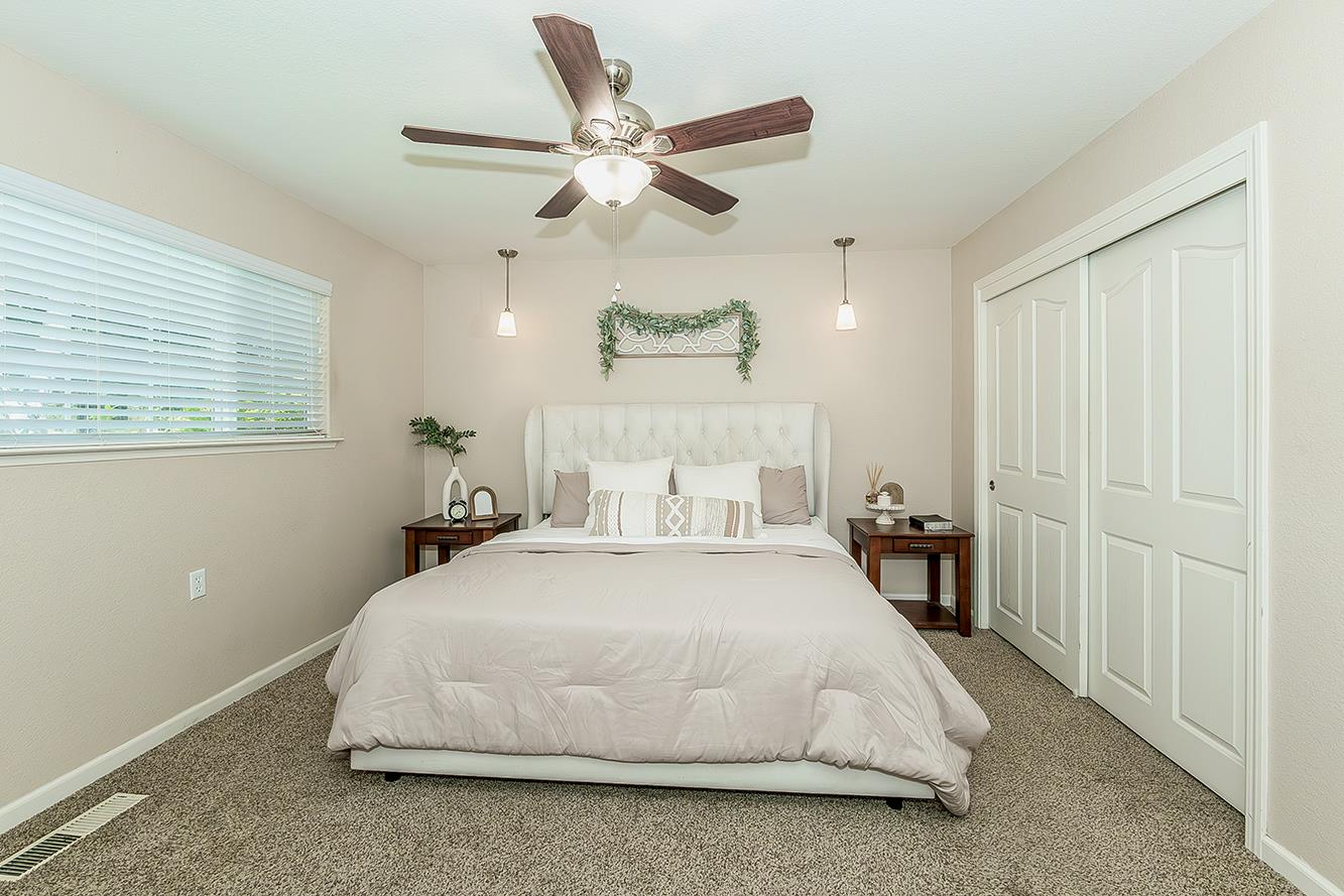 1563 South Klein Avenue Reedley, CA 93654 - Photo 31 of 81 a spacious bedroom with a bed and a chandelier