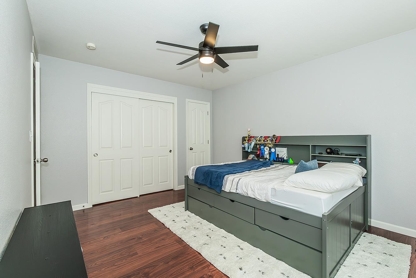 1563 South Klein Avenue Reedley, CA 93654 - Photo 36 of 81 a bedroom with a bed and wooden floor