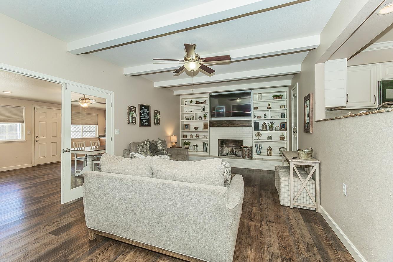 1563 South Klein Avenue Reedley, CA 93654 - Photo 10 of 81 a living room with furniture a fireplace and a ceiling fan