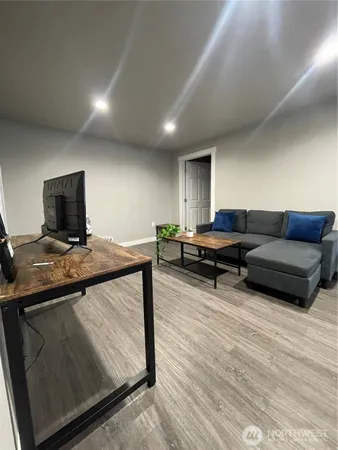 a living room with furniture a flat screen tv and a table