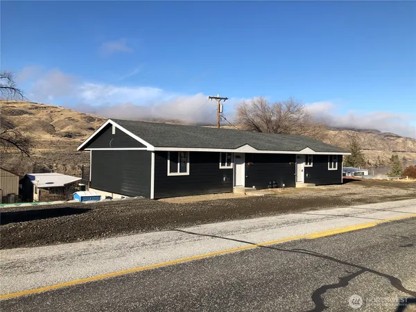 a front view of a house with a road