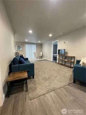 a living room with furniture and a wooden floor
