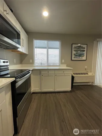 a kitchen with stainless steel appliances a stove a sink and a microwave