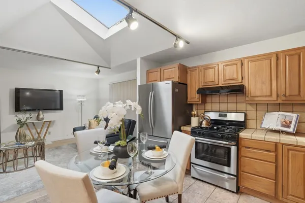 a kitchen with a dining table chairs and white appliances