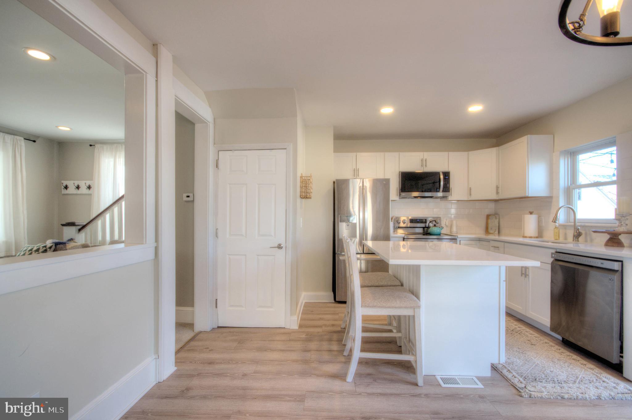23 East Holly Haddon Township, NJ 08107 - Photo 13 of 35 a kitchen with stainless steel appliances granite countertop a refrigerator a stove a sink dishwasher and white cabinets with wooden floor