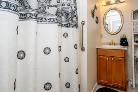 a bathroom with a sink a mirror a vanity and a shower