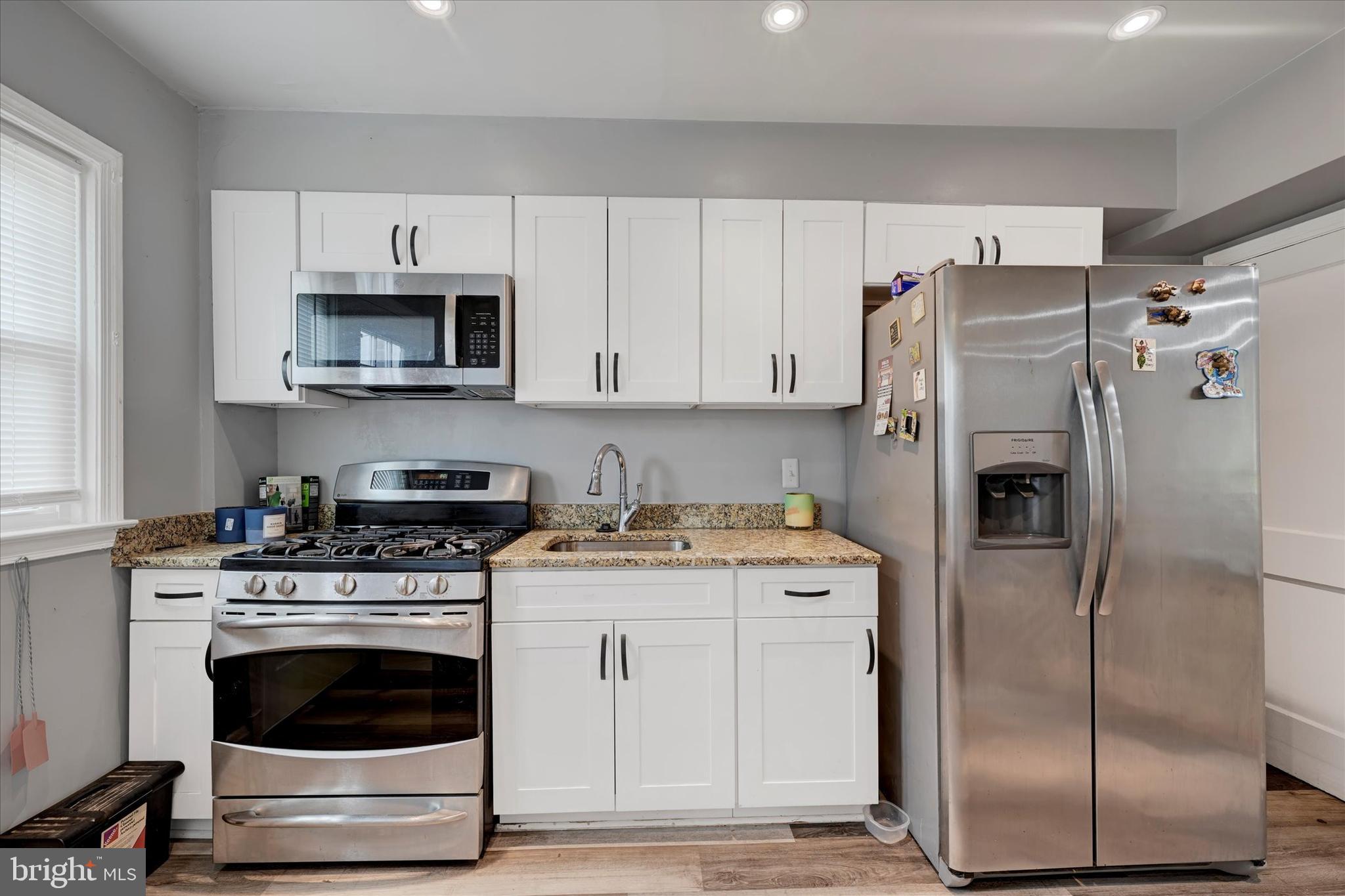 825 Wicklow Road Baltimore, MD 21229 - Photo 7 of 15 a kitchen with white cabinets and stainless steel appliances