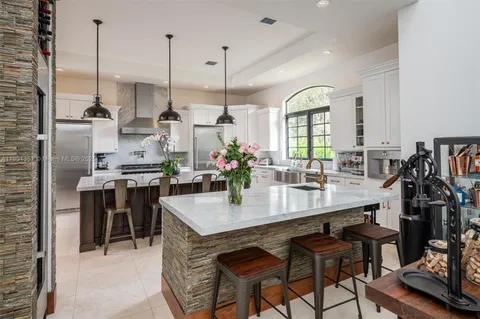 a kitchen with a stove kitchen island a sink stove and refrigerator