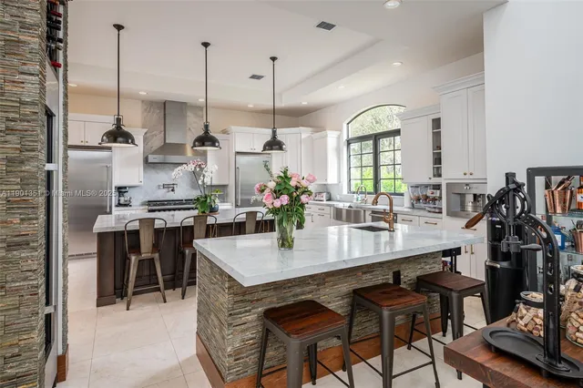 a kitchen with a stove kitchen island a sink stove and refrigerator