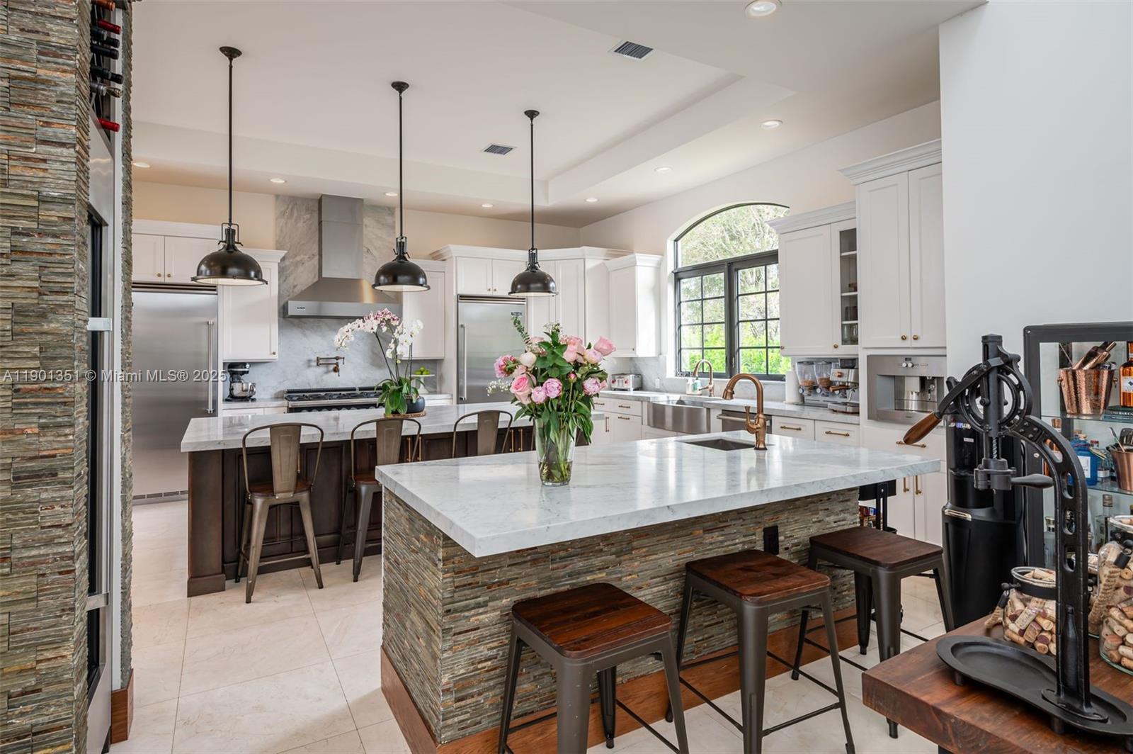 18951 Southwest 53rd Street Southwest Ranches, FL 33332 - Photo 20 of 57 a kitchen with stainless steel appliances kitchen island granite countertop a table chairs in it and wooden floors