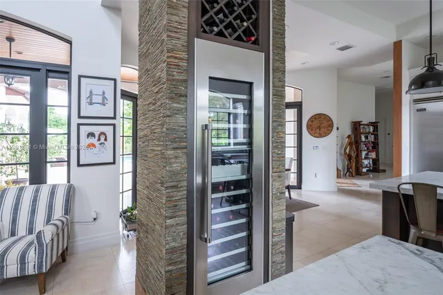 a kitchen with stainless steel appliances granite countertop a table chairs in it and white cabinets