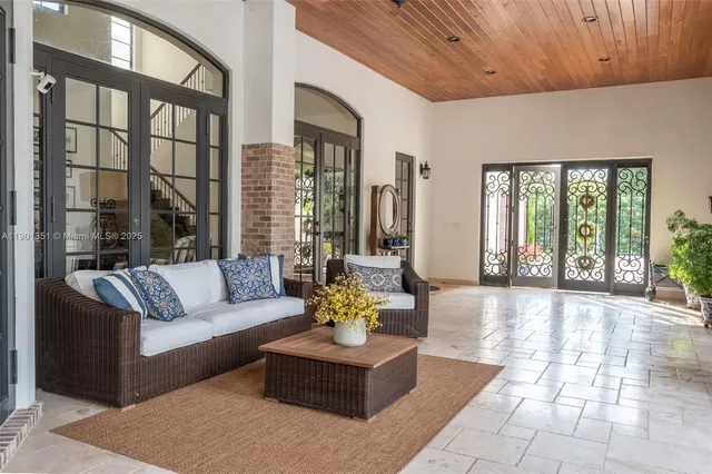 a living room with furniture a chandelier and a large window