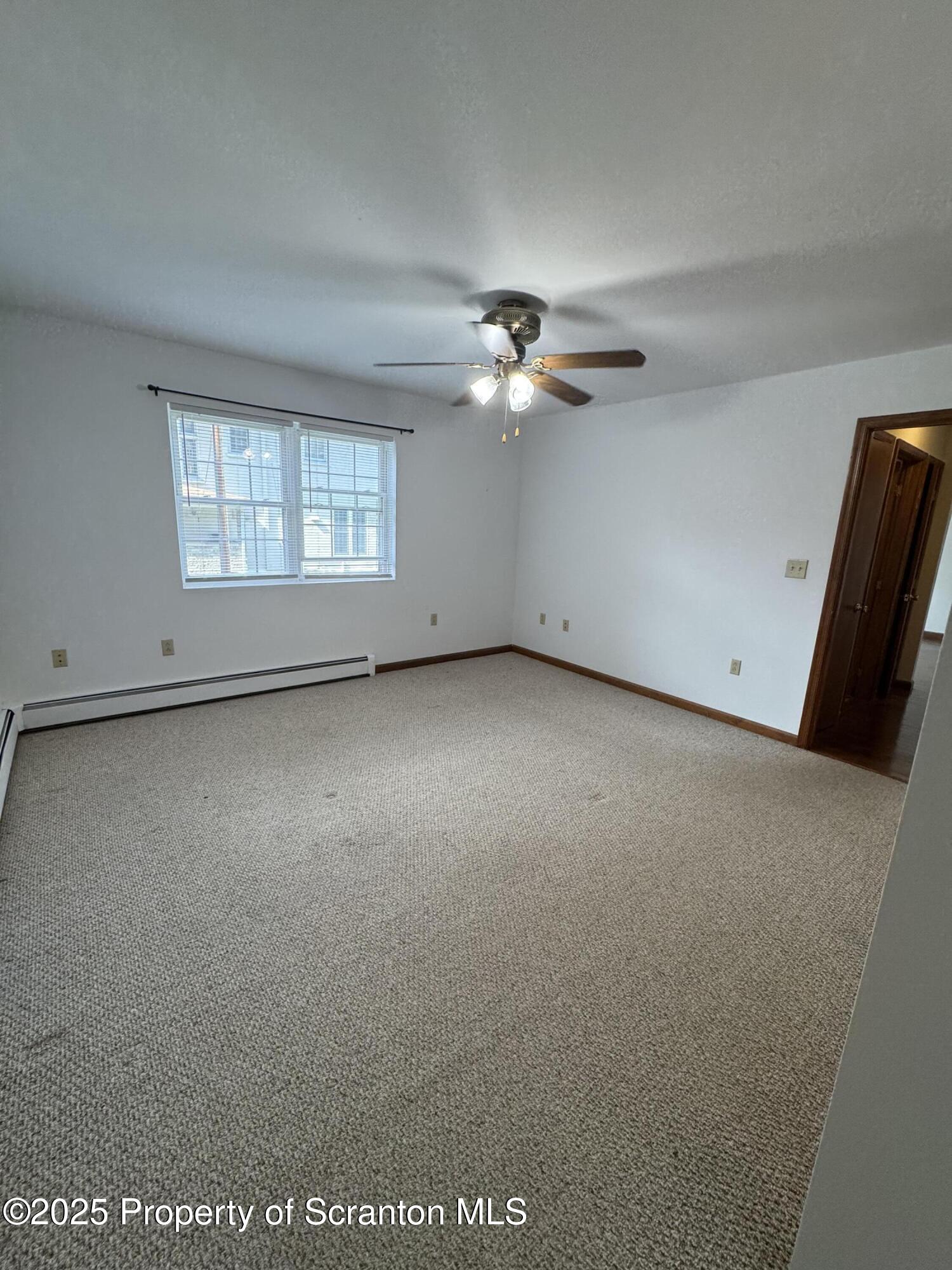 622 Terrace Street, Unit 1R Dunmore, PA 18512 - Photo 15 of 17 an empty room with windows and chandelier fan