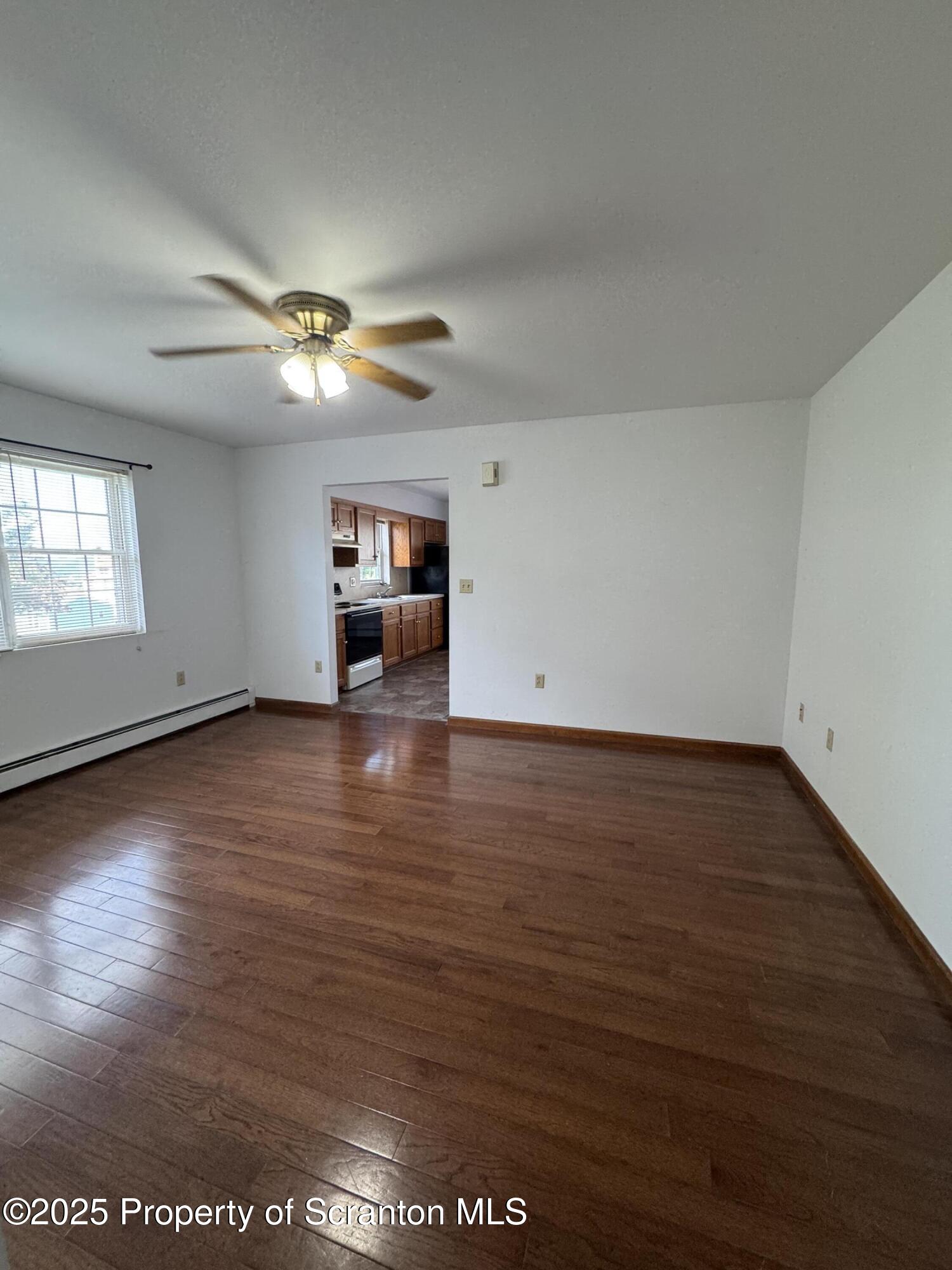622 Terrace Street, Unit 1R Dunmore, PA 18512 - Photo 6 of 17 an empty room with wooden floor chandelier fan and windows